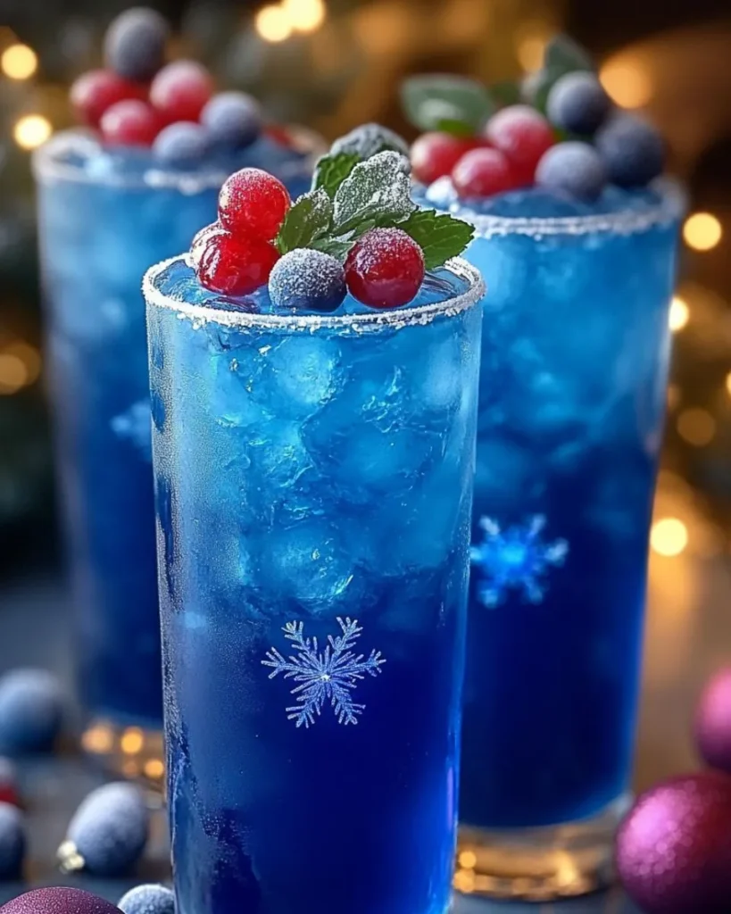 A glass of Blue Frost Christmas Glow Punch garnished with fresh pineapple, maraschino cherries, and mint leaves, showcasing its vibrant blue color and festive presentation.