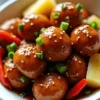 Glossy sweet and sour meatballs with sticky sauce, pineapple, and peppers – the perfect party appetizer